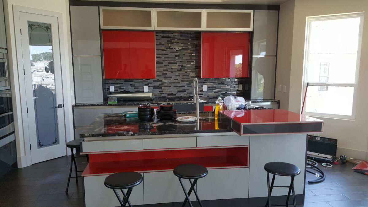 High gloss lux material kitchen. Red Kitchen. built-in appliances. Island sink space.