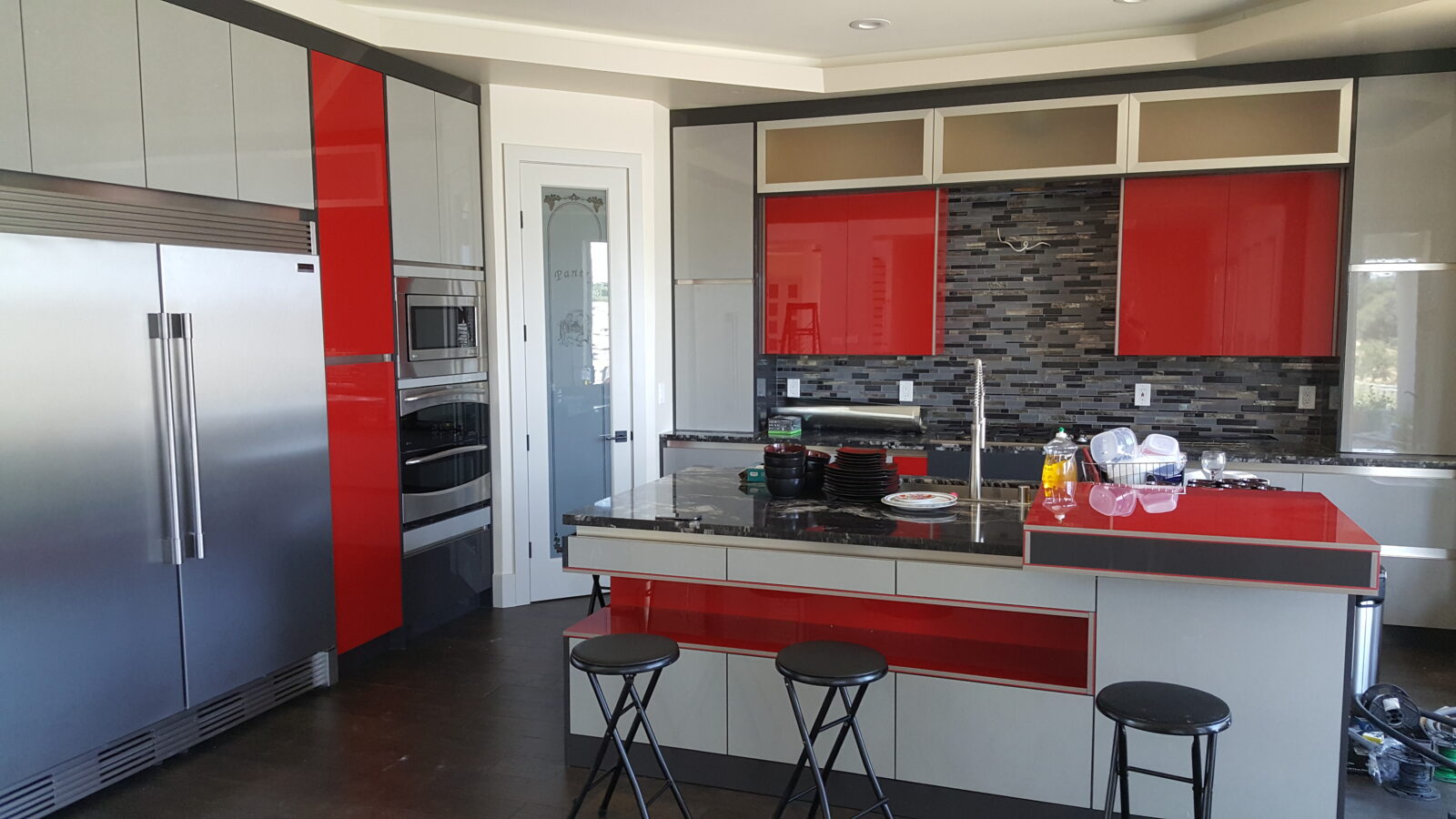 High gloss lux material kitchen. Red Kitchen. built-in appliances. Island sink space.
